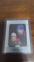 Front photo of the Nick Suzuki rookie card in protective casing showing player portraits and card details