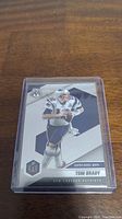 Front of Tom Brady Panini Mosaic football card encased in plastic sleeve, showing Brady in Patriots uniform with 'Super Bowl MVPs' label.