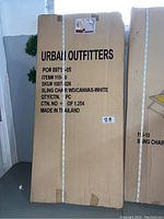 Photo of the cardboard box for one Urban Outfitters sling chair, showing product details and branding.