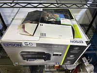 Epson WorkForce WF-2650 printer in its original box showing front and top of packaging with product image and features
