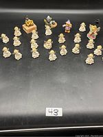 Full set of 20 angel figurines in front, and 4 additional decorative figurines in back row on black background.