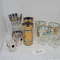 Full set of 9 glasses with various gold trimmed decorative patterns shown.