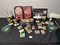 Full overview of the lot showing hats, sports cards, signs, trophies and framed photo.