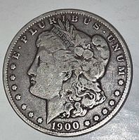 Obverse side of the 1900-O Morgan Silver Dollar showing Lady Liberty profile with wear and tarnishing.