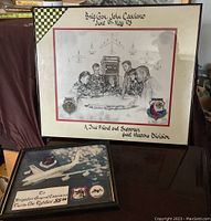 Full view of two framed mementos for Brigadier General John Casciano, including a large signed drawing with patches and a framed photo with patches.