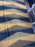 Close view of wool rug fabric and geometric zigzag color pattern showing condition and texture details.