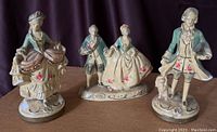 Photo of three vintage chalk figures showing detailed 18th-century style clothing, pastel colors, and overall condition
