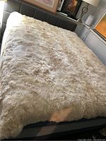 Blanket laid flat on bed showing full coverage and pile texture.