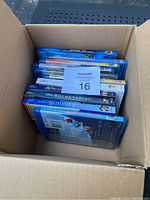Open box showing multiple Disney Blu-Ray movie cases stacked inside, all in blue Blu-Ray cases.