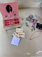 Lenox Childhood Memories ballerina music box open showing pink interior and ballerina figurine, alongside assorted costume jewelry laid out.