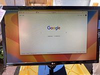 Front view of LG 24-inch LED monitor powered on displaying Google search page, showing screen and bezel condition properly.