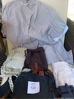 Aprons and maid's dress displayed on chair showing various fabric striped aprons and garments