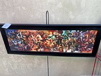Full view of the framed panoramic Marvel Comics artwork showing multiple characters across a wide, textured print.