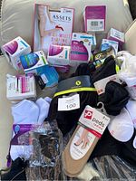 Overview of new and some used socks and pantyhose in packages and loose in a bag.