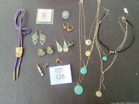 Full overview of jewelry collection including bolo tie, earrings, rings, and necklaces displayed on flat surface.