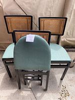 Three vintage folding Stakmore chairs showing cane backs and teal upholstered seats.