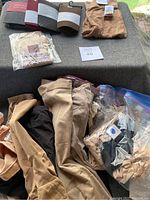 Assortment of tights, leggings and shapewear displayed on a surface, showing various colors and packaging.