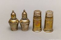 Two pairs of tarnished sterling silver weighted salt and pepper shakers with perforated tops.