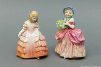 Front angled view of both porcelain figurines, showing detailed dresses and facial expressions.