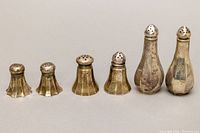 Photo showing all three pairs of sterling silver salt and pepper shakers, arranged side by side, highlighting size and shape differences.