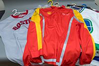 Photo shows Ferrari, Boston, and Vancouver jerseys on hangers, highlighting Ferrari jacket and Boston jersey