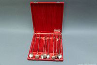 Full set of nine silver ice-tea spoons displayed inside original red box with satin lining.