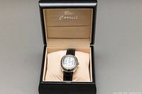 Watch in open black presentation box with beige interior and pillow