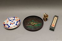 All four items together: hand painted plate, lacquer tray, Mudman figurine, boxed hand fan.