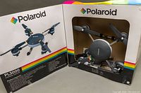 Polaroid PL3000 drone visible in original open box with product image on lid and colorful rainbow stripes.