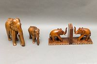 All items displayed in one image, showing the pair of elephant bookends with two different sized elephant sculptures, highlighting the wood grain and sizes.