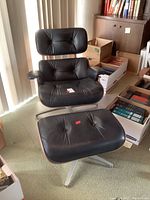 Front view of lounge chair and ottoman on carpet with clear floor protector under chair base