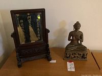 Wood framed mirror with black backing and gold brush writing, ornate carved legs