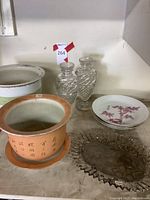 Overview of terracotta pot, white planter, cut glass vases, porcelain bowl and glass dish