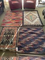 Overview of four wool rugs arranged on floor: multicolor kilim, tree of life, Persian floral, fish motif