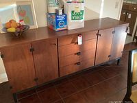 Front view of sideboard showing doors, drawers and metal hardware