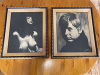 Two black and white framed portraits on floor, showing a topless woman and a young man, both signed Lance 75.