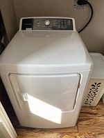 Front view of white Frigidaire electric dryer with closed door and top control panel