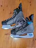 Side view of Nike Bauer Supreme Pro ice skates showing overall design, branding, and condition