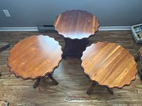 Top view of three wooden side tables showing scalloped round tops and base designs
