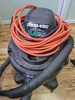 Top view of Shop-Vac showing the brand label and motor horsepower (3.0 Peak HP) with orange extension cord coiled around.