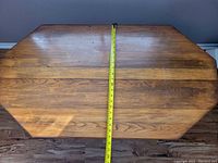 Top view of wooden table with measuring tape showing approximately 30 inches width.