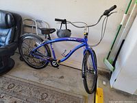 Side view of the blue GX7 cruiser bicycle showing overall frame, tires, and seat with helmet attached