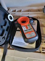 Black & Decker BullsEye stud finder with carrying case and manual on beige surface