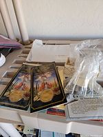 Two gold-tone Super Bowl commemorative coins on display cards with desert and football imagery, positioned among various paper items.