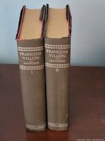 Two old hardcover books titled François Villon by Nicolson, volumes I and II, with worn brown cloth covers and damaged spines.