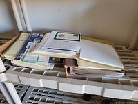 Various binders and folders containing stamp albums, loose pages and printed material related to stamps and philately.
