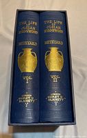 Two volume books in slipcase with blue cloth cover and gold embossed text and decoration.