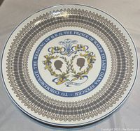 Front of Royal Tuscan commemorative plate with intricate gold and blue border and royal wedding silhouettes