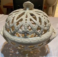 Front view of white Wedgwood porcelain round bowl with lid on, showing intricate open lattice design and finial handle on lid.