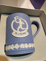 Blue jasper commemorative mug with Olympic torch runner relief and decorative band at bottom